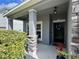 Welcoming entryway featuring a black door, stone pillar detail, a wreath and plants at 10934 79Th E St, Parrish, FL 34219