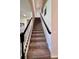 Carpeted staircase with a dark wood railing and white spindles, leading to the upper level of the home at 10934 79Th E St, Parrish, FL 34219
