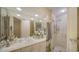 Spacious bathroom featuring marble countertops, dual sinks, large mirrors, and glass door shower at 1241 Gulf Of Mexico Dr # 603, Longboat Key, FL 34228
