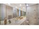 Well-lit bathroom with double sinks, walk-in shower, and detailed dolphin-themed wall decor at 1241 Gulf Of Mexico Dr # 603, Longboat Key, FL 34228