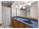 Bathroom features double sinks with blue countertops and a tile shower with nautical shower curtain at 1411 70Th Nw St, Bradenton, FL 34209