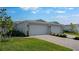 Charming villa exterior features a two car garage, brick paver driveway and beautiful landscaping at 16114 Ivy Ridge Ct, Port Charlotte, FL 33953