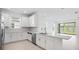 Modern kitchen featuring white cabinetry, stainless steel appliances, and a large island with quartz countertops at 16114 Ivy Ridge Ct, Port Charlotte, FL 33953