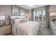 Inviting main bedroom featuring plush bedding, tray ceiling, and views of the neighborhood at 16114 Ivy Ridge Ct, Port Charlotte, FL 33953