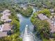 Aerial view of a canal neighborhood with homes and a boat navigating the waterway at 1711 Pelican Cove Rd # 443, Sarasota, FL 34231