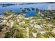 Aerial view of a community near the water showcasing a pool, tennis court, and lush greenery at 1711 Pelican Cove Rd # 443, Sarasota, FL 34231