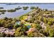 An aerial view shows a cluster of homes nestled on a lush peninsula surrounded by shimmering waters at 1711 Pelican Cove Rd # 443, Sarasota, FL 34231