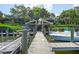 Community boat dock featuring boat slips and a kayak storage rack with boats docked alongside wooden planks at 1711 Pelican Cove Rd # 443, Sarasota, FL 34231
