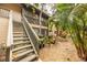 Exterior view showcases stairs leading to a second-story unit surrounded by lush landscaping at 1711 Pelican Cove Rd # 443, Sarasota, FL 34231