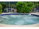 Close-up of a bubbling hot tub surrounded by lush greenery and outdoor seating at 1711 Pelican Cove Rd # 443, Sarasota, FL 34231