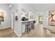 Eat-in kitchen with white cabinetry, bar seating and views to the front door and living area at 1711 Pelican Cove Rd # 443, Sarasota, FL 34231