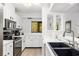 Modern kitchen featuring black appliances, sleek white countertops, and plenty of storage space at 1711 Pelican Cove Rd # 443, Sarasota, FL 34231