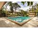 Rectangular community swimming pool surrounded by lounge chairs and manicured landscaping at 1711 Pelican Cove Rd # 443, Sarasota, FL 34231