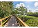 Scenic wooden boardwalk winding through lush greenery, offering a tranquil path surrounded by natural beauty near the water at 1711 Pelican Cove Rd # 443, Sarasota, FL 34231