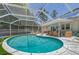 Backyard retreat with screened pool, patio lounge, and outdoor dining under a tropical sky at 1960 Lincoln Dr, Sarasota, FL 34236