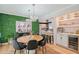 Stylish dining area showcases a round wood table, green grass wall, and seamlessly connects to the modern kitchen at 1960 Lincoln Dr, Sarasota, FL 34236
