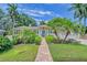 Charming home featuring a brick walkway, lush landscaping, and a welcoming blue front door at 1960 Lincoln Dr, Sarasota, FL 34236