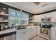 Modern kitchen boasts white cabinets, stainless steel appliances, open shelves, and a dark backsplash at 1960 Lincoln Dr, Sarasota, FL 34236