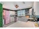 Charming kitchen features white cabinets, countertops, stainless appliances, and a lovely pink Smeg refrigerator at 1960 Lincoln Dr, Sarasota, FL 34236