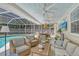Covered lanai with ceiling fans includes a lounge area, dining table, and pool views at 1960 Lincoln Dr, Sarasota, FL 34236