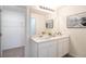 Modern bathroom with double vanity, a large mirror, updated lighting, and ample countertop space at 21061 Delake Ave, Port Charlotte, FL 33954