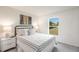 Bedroom featuring a neutral palette, carpeted floors, a large window, and coordinated bedside tables at 21061 Delake Ave, Port Charlotte, FL 33954