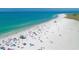 Aerial view of a vibrant beach with many colorful umbrellas dotting the white sand, ideal for summer relaxation at 2267 Pueblo Ln # V40, Sarasota, FL 34231