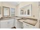 Bathroom vanity featuring granite countertops, white cabinets, and dual mirrors with ample counter space at 2267 Pueblo Ln # V40, Sarasota, FL 34231