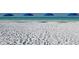 Sandy beach scene with blue umbrellas and a turquoise ocean backdrop at 2267 Pueblo Ln # V40, Sarasota, FL 34231
