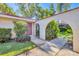 Inviting home entrance with an arched entryway and lush tropical foliage at 2267 Pueblo Ln # V40, Sarasota, FL 34231
