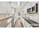 Bright kitchen featuring granite countertops, stainless steel appliances, white cabinets, and tile floors at 2267 Pueblo Ln # V40, Sarasota, FL 34231