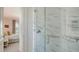Modern bathroom boasts glass shower with marble tile, a chrome grab bar, and access to an adjacent bedroom at 228 Saint James Park, Osprey, FL 34229