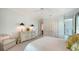 Bright bedroom with white bedding, a ceiling fan, closet doors, and an ensuite bathroom, providing ample storage at 228 Saint James Park, Osprey, FL 34229