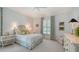 Bright bedroom features a ceiling fan, white bedding, patterned curtains, and light-colored wood furnishings at 228 Saint James Park, Osprey, FL 34229