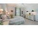 Bright bedroom with a white bed, floral accents, natural light, a ceiling fan, and elegant decor at 228 Saint James Park, Osprey, FL 34229