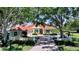 Charming one story home with brick driveway, lush green yard, and mature trees at 228 Saint James Park, Osprey, FL 34229