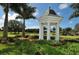Quaint gazebo overlooking a pond and surrounded by lush greenery and landscaping at 228 Saint James Park, Osprey, FL 34229