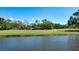 A beautiful view of the pond and trees off the lush green grass of the golf course at 228 Saint James Park, Osprey, FL 34229