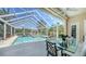 Inviting screened pool with a dining table, and an outdoor grill, perfect for relaxing and entertaining guests at 228 Saint James Park, Osprey, FL 34229