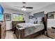 Bedroom features a wooden bed frame, dresser, ceiling fan and two windows for lots of natural light at 23088 Allen Ave, Port Charlotte, FL 33980