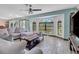 Bright living room with arch windows, blue accents, and sliding glass doors to outside covered deck at 23088 Allen Ave, Port Charlotte, FL 33980