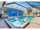 Relaxing screened-in pool and spa with a bright blue accent wall and bar area, perfect for outdoor entertaining at 23088 Allen Ave, Port Charlotte, FL 33980
