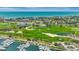 Beautiful aerial shot showcasing a golf course, marina with boats, and the cityscape against a backdrop of the ocean at 2450 Harbourside Dr # 233, Longboat Key, FL 34228
