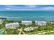 Wide aerial photograph features well-maintained waterfront condos surrounded by tropical greenery and beautiful ocean views at 2450 Harbourside Dr # 233, Longboat Key, FL 34228