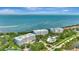 Expansive aerial view showcases waterfront condos, a shimmering ocean backdrop, and lush community landscaping at 2450 Harbourside Dr # 233, Longboat Key, FL 34228