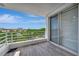 Balcony with sliding glass doors boasts views of lush landscaping and city skyline at 2450 Harbourside Dr # 233, Longboat Key, FL 34228