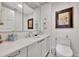 Neat bathroom with white vanity, framed artwork, mirror, and modern toilet at 2450 Harbourside Dr # 233, Longboat Key, FL 34228