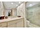 Bright bathroom featuring marble vanity and glass-enclosed shower with seating at 2450 Harbourside Dr # 233, Longboat Key, FL 34228