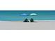 Couple relaxing in chairs under beach umbrellas on the pristine sandy beach at 2450 Harbourside Dr # 233, Longboat Key, FL 34228