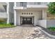Driveway leading to a gated entrance with brick pavers and lush landscaping at 2450 Harbourside Dr # 233, Longboat Key, FL 34228
